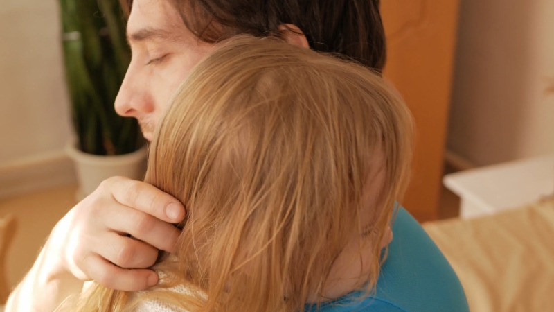 Parent calmly hugging a child during emotional distress after a meltdown or tantrum