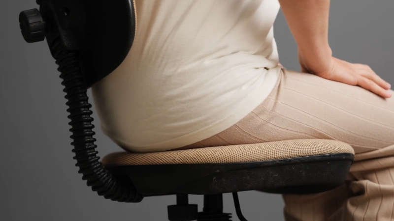 Person sitting upright on an office chair with proper posture to reduce visual fatigue