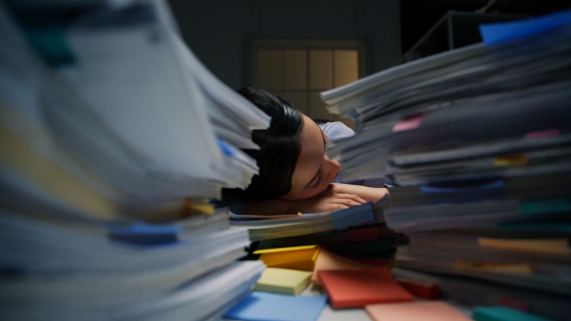 Student surrounded by stacked papers and books showing neurodivergent burnout