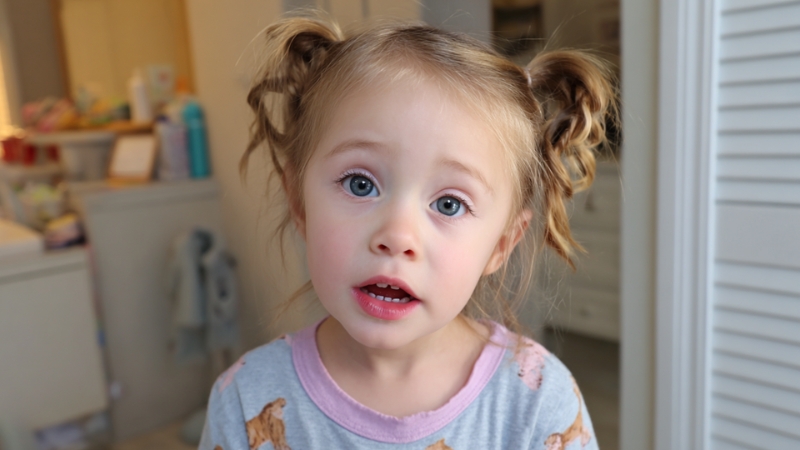 2-year-old girl looking at the camera with a questioning expression