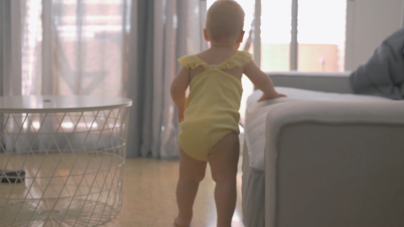 Baby stands and holds furniture while learning to move and balance
