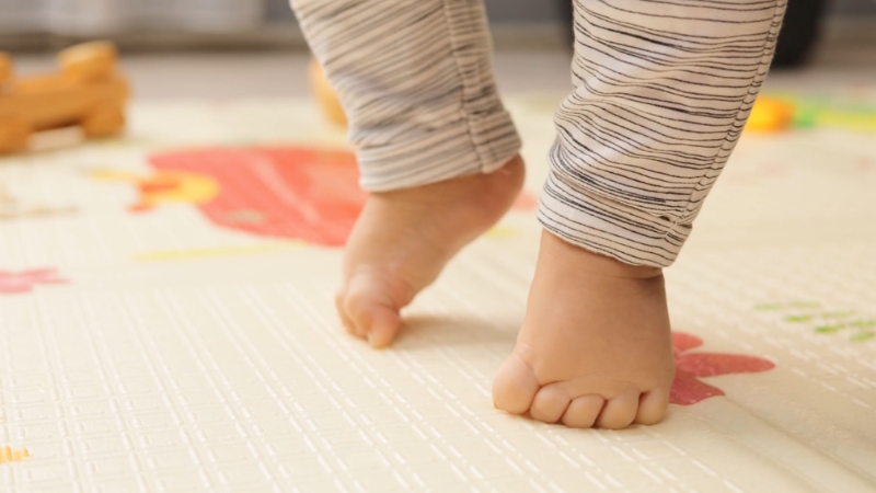 Baby standing with unstable feet posture showing low muscle tone in infants