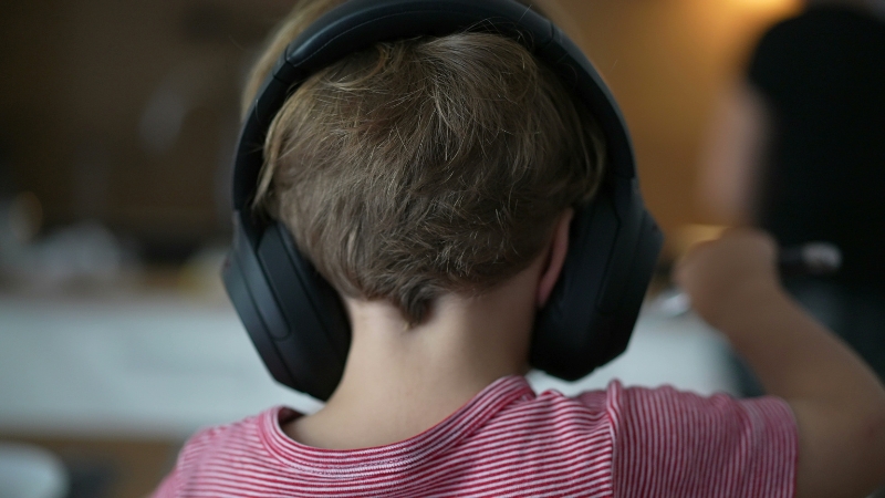 Child wearing noise canceling headphones to reduce sensory overload