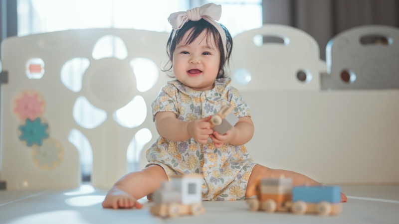6-month-old baby sitting and holding a toy while practicing balance and hand coordination