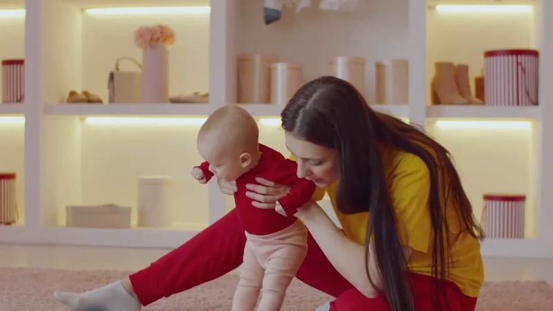 Mother supports baby with weak posture during standing, showing low muscle tone in infants