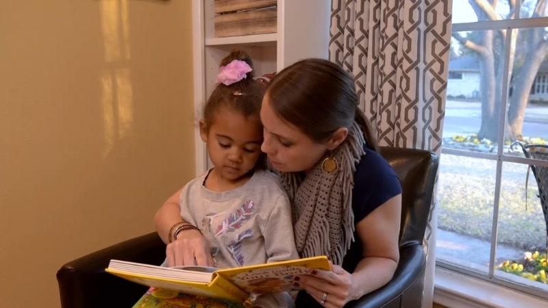 Parent reads a picture book with a young child at home