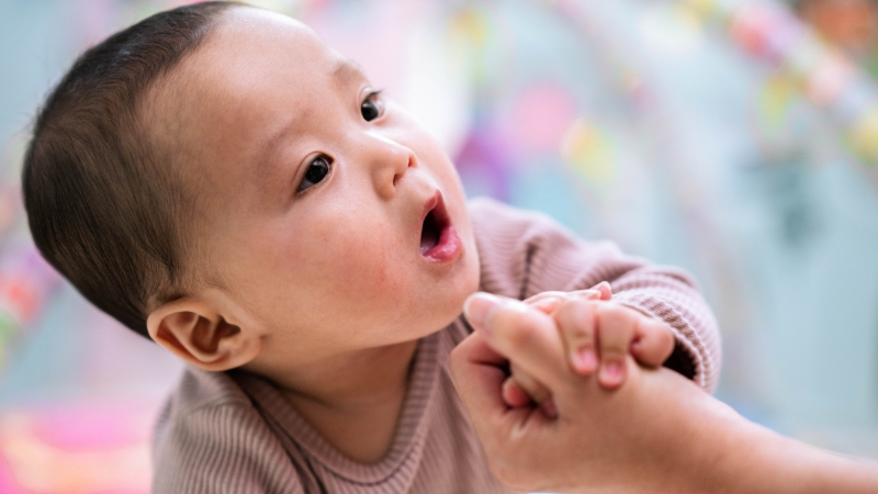 2-year-old not talking child reaching and vocalizing during interaction